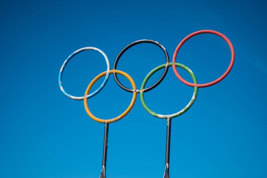 Olympic rings on poles against a blue sky